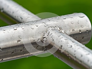 Rain drops on a gray metallic construction  of chrome bars