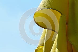 rain drops on isolated yellow color closed parasol, sun umbrella