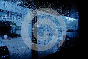 Rain drops pouring down on window glass