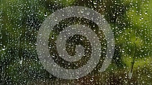 Rain drops on rainy day on outside window glass