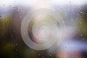 Rain drops running down dirty glass window pane. Summer time
