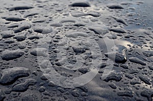 Rain drops on top of the dark car roof