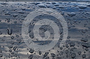 Rain drops on top of the dark car roof