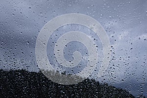 Rain drops window glass. Rainy day sky view through window