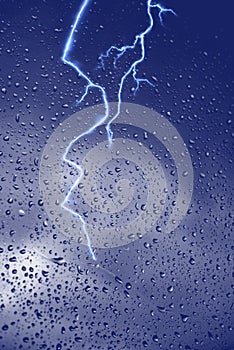 Rain drops window glass and stormy lightning nature weather forecast defocus background