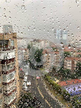 Rain drops on a window pane against city view photo