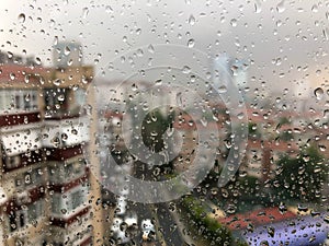 Rain drops on a window pane against city view