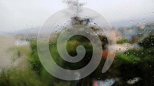 Rain drops on a window pane with blurred tree in background