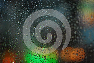 Rain drops on window with road light bokeh background