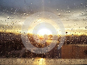 Rain drops on window and sun set