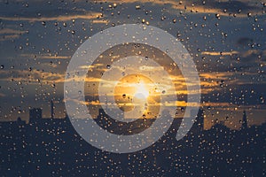 Rain drops on window - sunset sky background