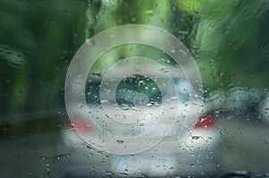 rain drops on windshield with blurred cars on backgro