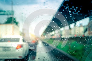 Rain drops on windshield. Car driving on asphalt road on rainy day. Windshield window of car with raindrops on glass windscreen.