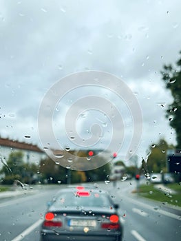 Rain drops on windshield of a car in traffic