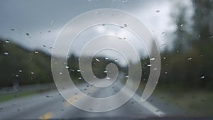 Rain drops on the windshield in driving car