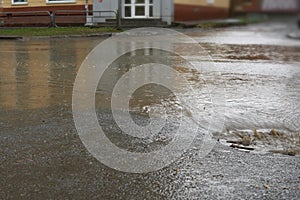 Rain falling on road, flowing through sewer drain