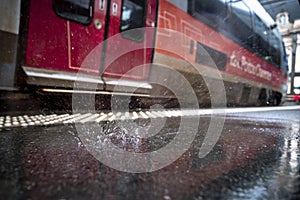 Rain falling on the station platform in front of a train