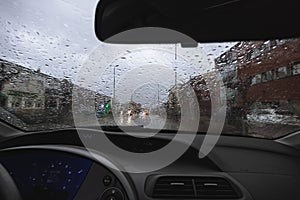 Rain falling on a windscreen while driving on a highway road without visibility