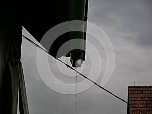 Rain flowing through the missing gutter on a rainy summer day