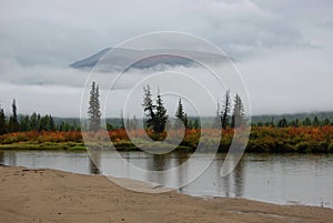 Rain, fog and low clouds on the mountain river.