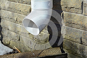 Rain gutter downspout pipe for roof water drainage and waterproofing house foundation wall.