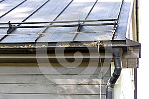 Rain gutter pipeline system installation. Roofing construction. Rain gutter system and roof protection from snow Snow guard