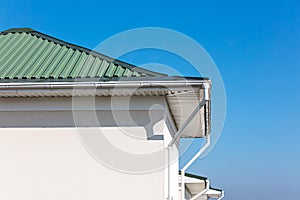 Rain gutter system with downspouts on rooftop of renovated house