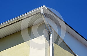 Rain gutters on a house. White gutter on the roof top of house.