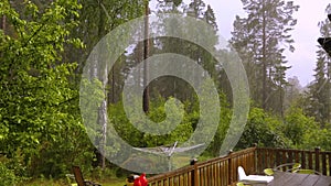 Rain with hail on wooden patio on summer day.