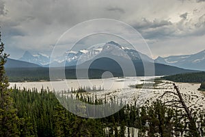 Rain and heavy clouds churn up the silt in the river, as seen from Howes Pass Lookout Banff National Park Alberta Canada