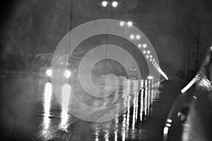 Rain at night on the road with street lights in the dark street