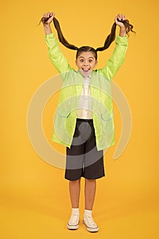 Rain is not hindrance. small girl have fun in raincoat. active schoolgirl waterproof cloak. water resistant clothes. in