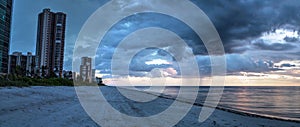 Rain pours from dark clouds over Pass Beach in Naples, Flor