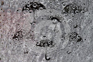 Rain. Raindrops fall down against the gray and white background with black umbrella silhouettes.