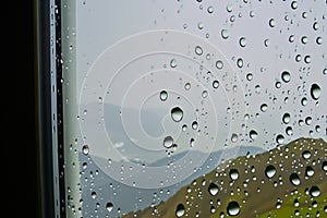 Rain. Raindrops on the window. Rainy day. Blue tone. Drops of water on the glass. Macro shooting. Texture