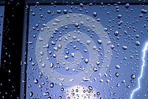 Rain. Raindrops on the window. Rainy day. Blue tone. Drops of water on the glass. Macro shooting. Texture