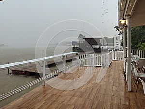 Rain storms hit the raft house by the water.