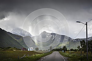 Rain and sunny spots on the road 888 Midnattsolveien near Sommarhus on the island AustvÃÂ¥gÃÂ¸ya, Lofoten islands, Norway photo