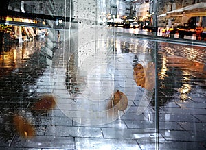 Rain in  town ,umbrella on asphalt on city street, ,modern building ,Rainy weather ,Autumn leaves on window frame ,wet drops ,nigh