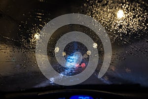 Rain water on a car windscreen affecting road visibility inside a dark tunnel