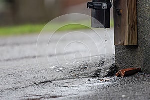 Rain water dropping from a pipe on a wall..