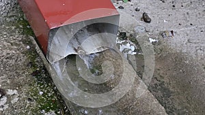 rain water flowing out of gutter slow motion