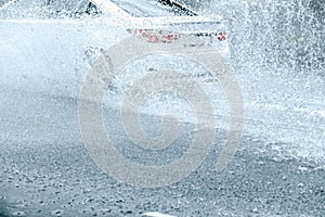 Rain water splashing from car wheels during heavy rain