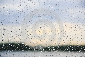 Rain on a Window with the Shore Line in the Background and Blue Sky