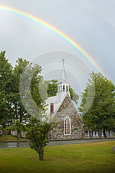 A rainbow above the Anglican stone-field church, St. Peter`s of Cookshire-Eaton in Estrie, Quebec, Canada