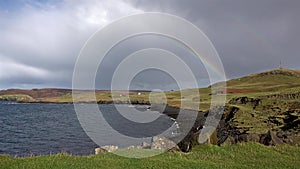 Rainbow above Duntulm Bay and castle on the Isle of Skye - Scotland