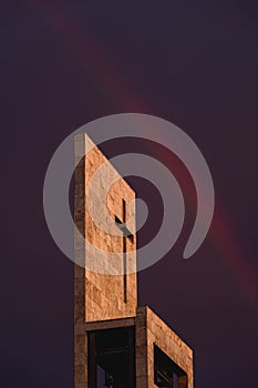 A rainbow above a modern church tower with christian cross