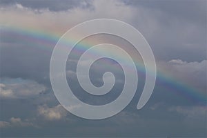 Rainbow above the north sea against a blue sky with clouds