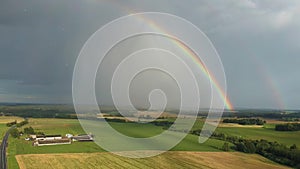 Rainbow Above Wheat Field.  Ripe Crop Field After Rain and Colorfull Rainbow in Background Rural Countryside. Aereal Dron Shoot.