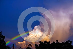 rainbow appears in the sky after the rain and back on sunset cloud